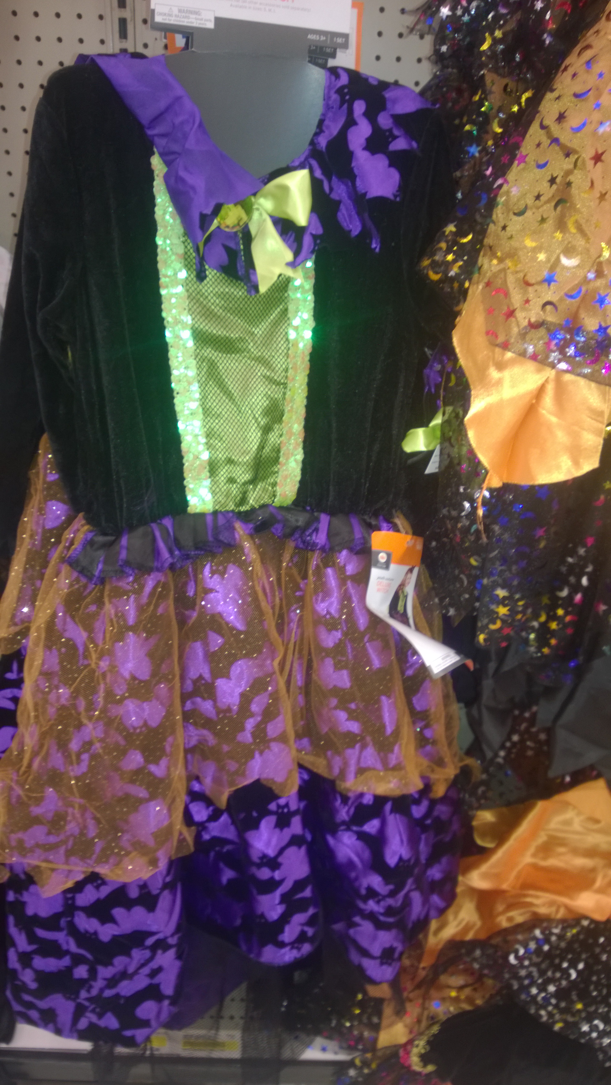 A green-and-purple dress-up outfit on a shop hanger.