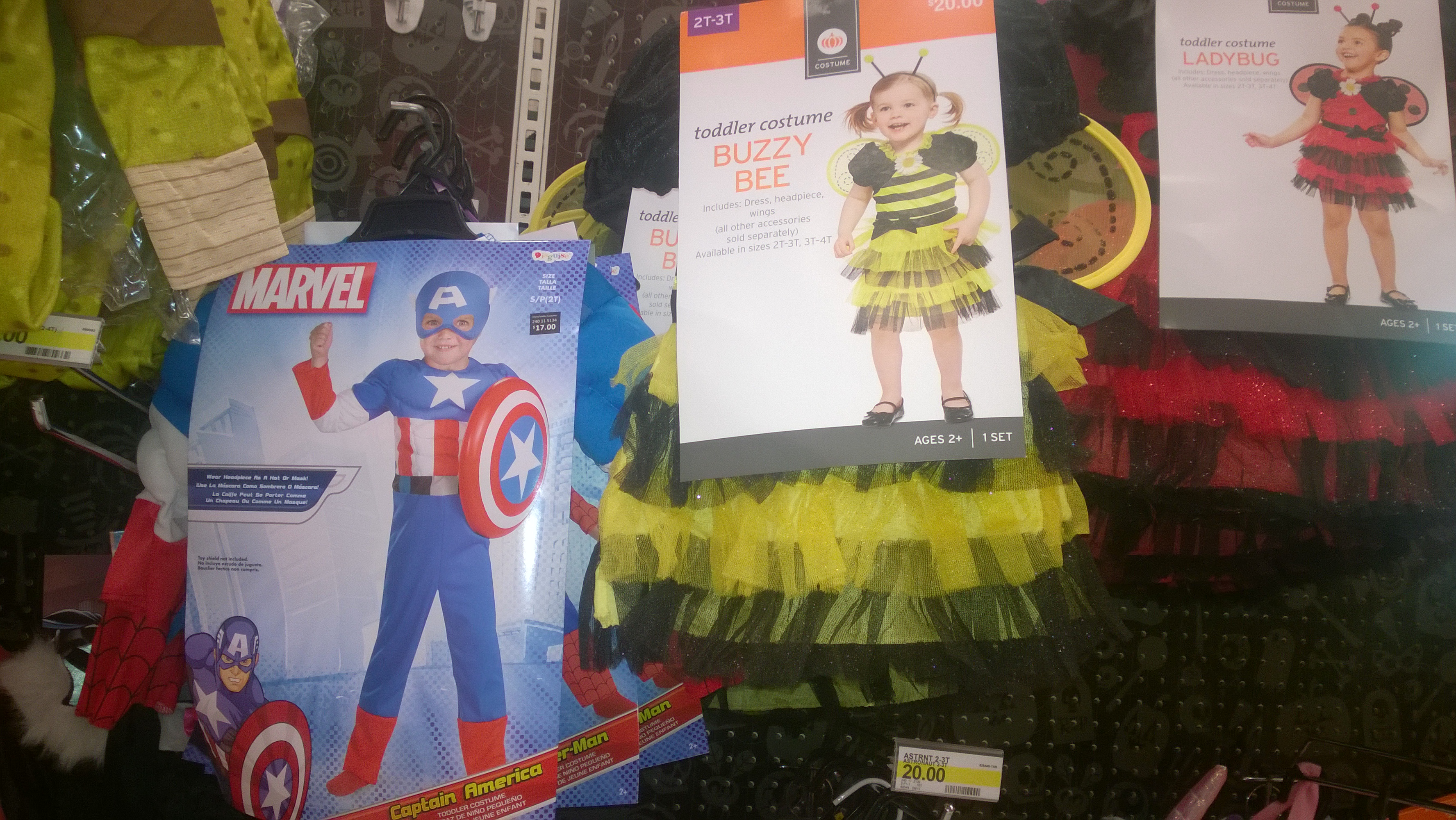 Packaged superhero and bumblebee costumes hanging on a retail display.