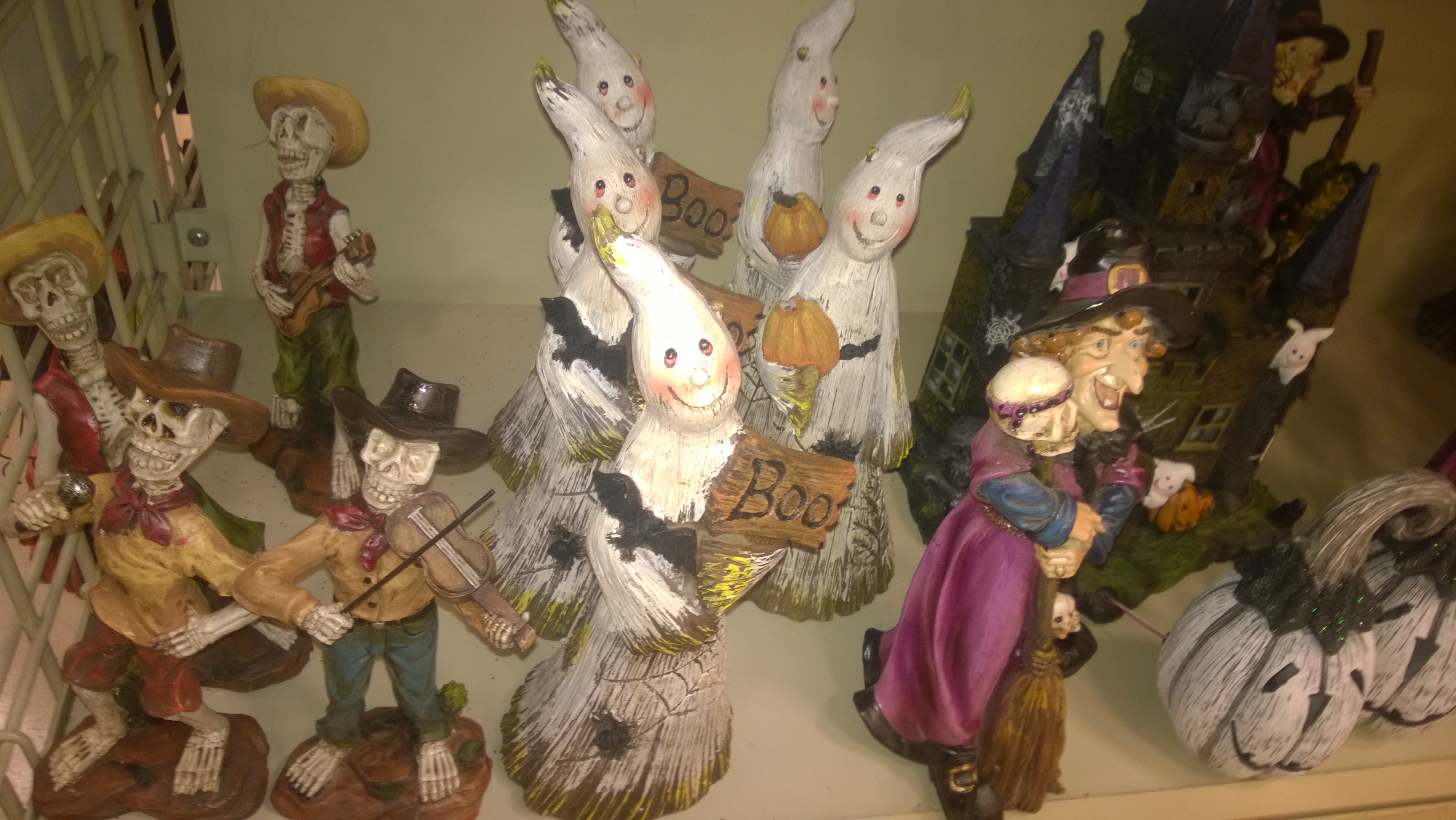 Friendly ghost and witch figurines arranged together on a shop display.